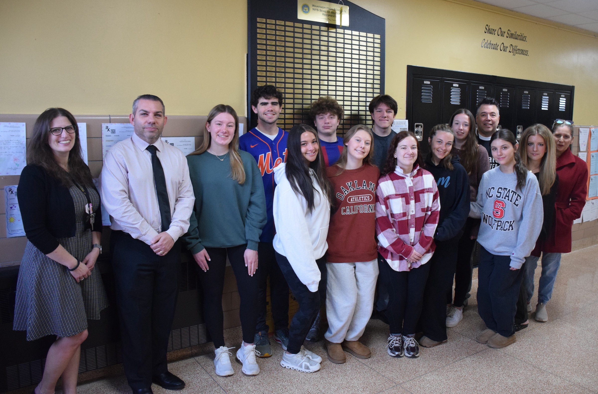 teen kids standing in front of large award plaque on wall